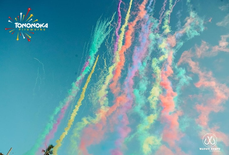 Colourful daytime smoke burst against a bright sky