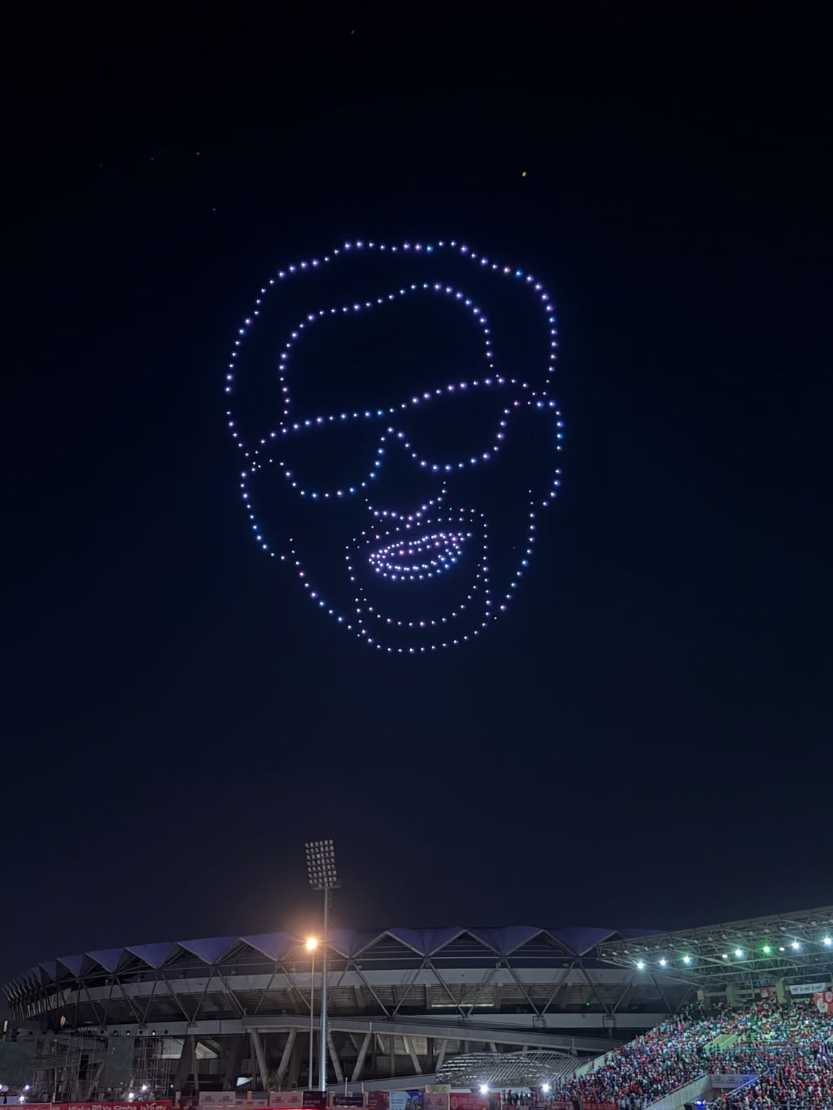 Synchronised drone light show forming shapes in the night sky